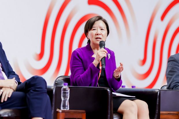 Nancy Ip speaking into microphone on stage.